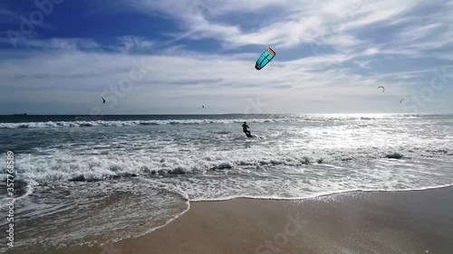 Kitesurfing in strong winds on the west coast under a blue sky