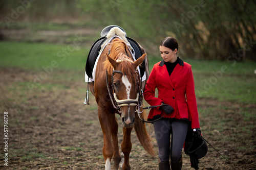Equestrian sport, young woman jockey is riding brown horse © Parilov