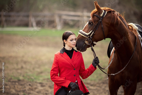 Beautiful woman jockey rider with brown horse outdoors