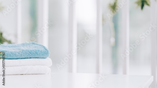 Stack of clean soft towels on blurred background