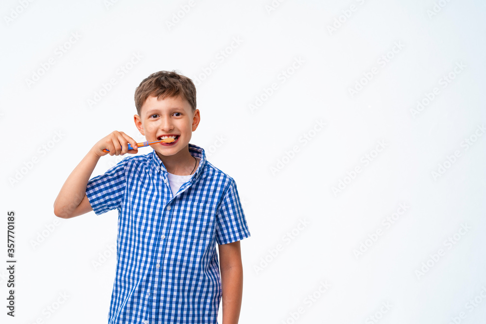 Happy 7-year-old Caucasian boy, smiling, brushing his teeth Happy 7-year-old Caucasian boy, smiling, brushing his teeth