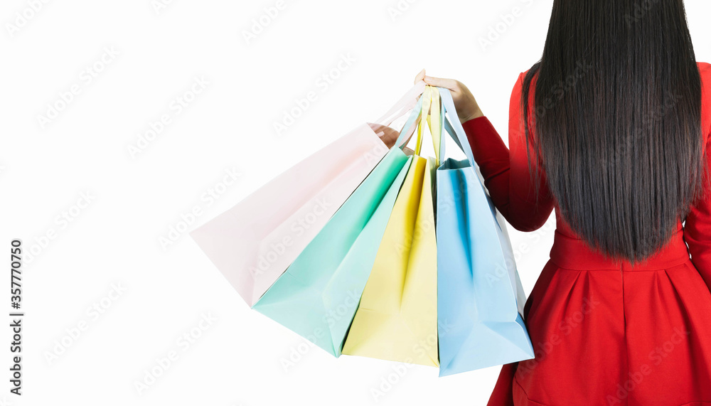 young beautiful woman in red dress carrying color pastel shopping bag isolated on white banner background with copy space