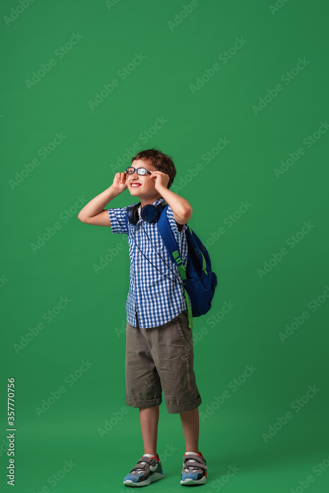 Happy cute smart boy in glasses with school bag and headphones. Happy cute smart boy in glasses with school bag and headphones.