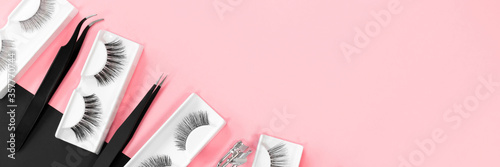 Tablou canvas Various tools for eye lash extensions on a trendy pastel pink and black background