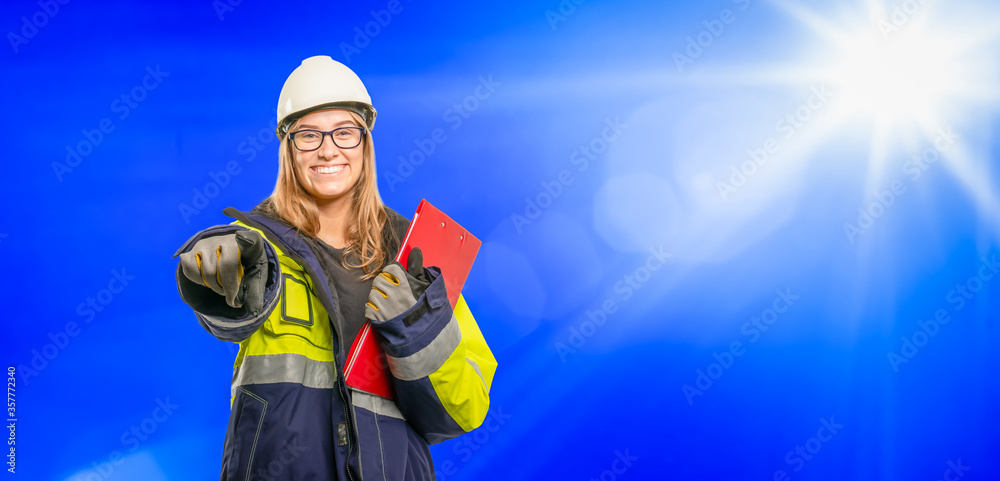 young apprentice in safety clothing with clipboard advertises her job