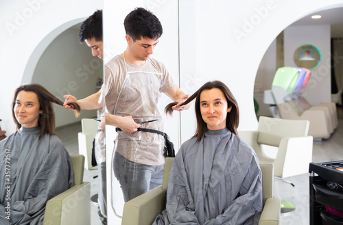 Glad male hairdresser and client getting haircut