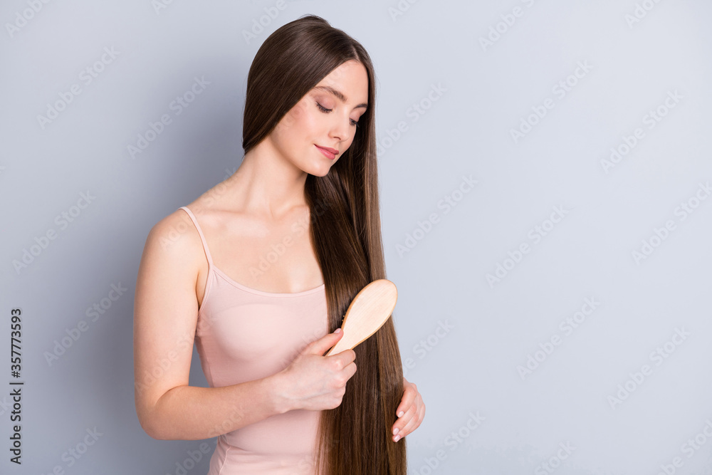 Photo of beautiful attractive model lady long ideal hairdo hold favorite wooden comb brushing strong natural curls wear beige singlet isolated grey color background Photo of beautiful attractive model lady long ideal hairdo hold favorite wooden comb brushing strong natural curls wear beige singlet isolated grey color background