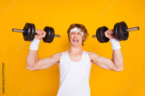 Close-up portrait of his he nice attractive funky gloomy guy sportsman lifting heavy barbell doing work out crying healthy life regime isolated over bright vivid shine vibrant yellow color background