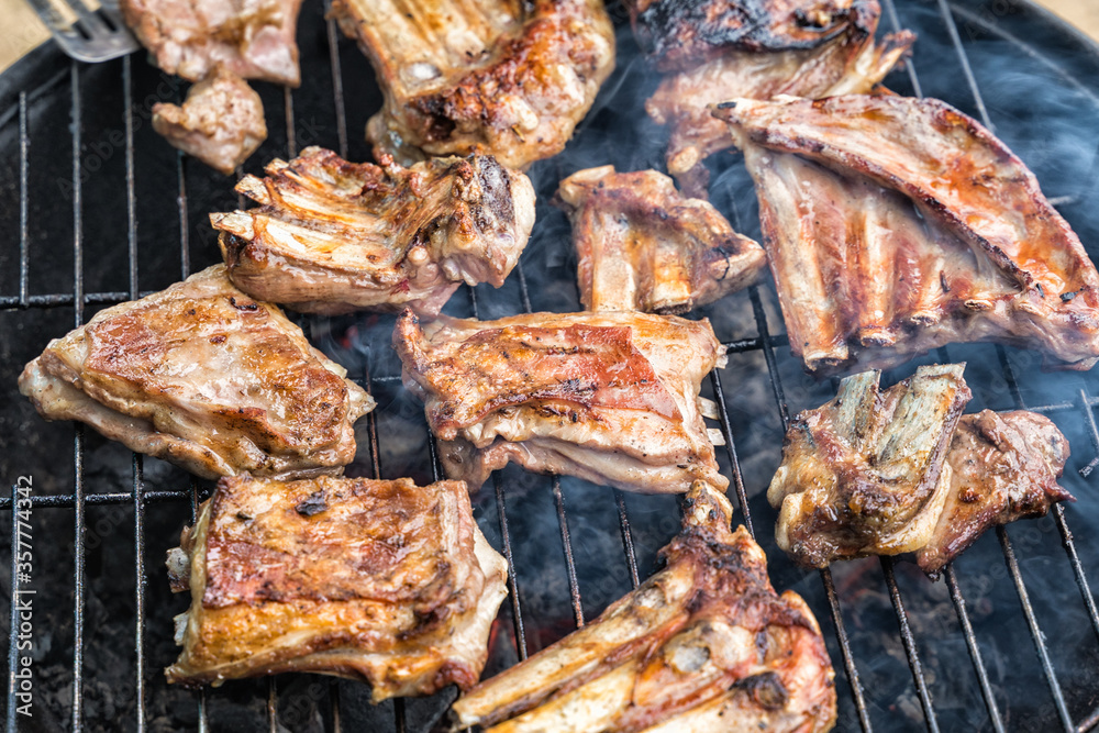 Lamb ribs are cooked on a round grill with spices.