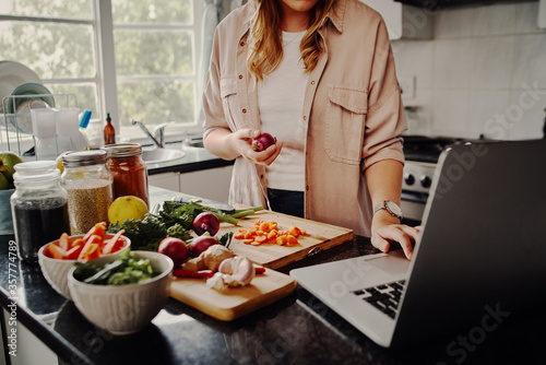 Fotografia Young female blogger searching online browsing for recipes to prepare salad of f
