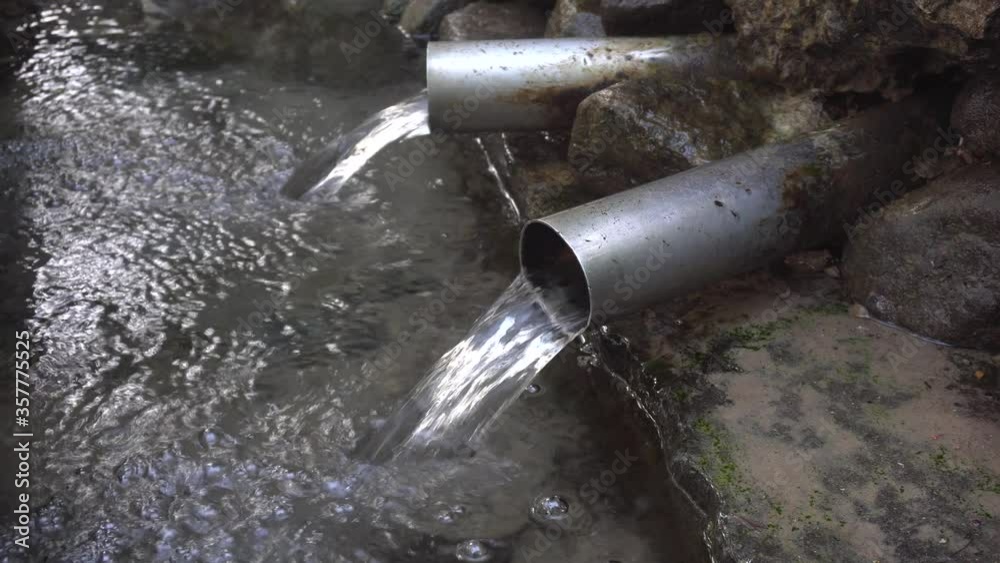 Spring of natural water in the district Krylatskoye (Moscow, Russia) close-up. Source water flows from two pipes Spring of natural water in the district Krylatskoye (Moscow, Russia) close-up. Source water flows from two pipes