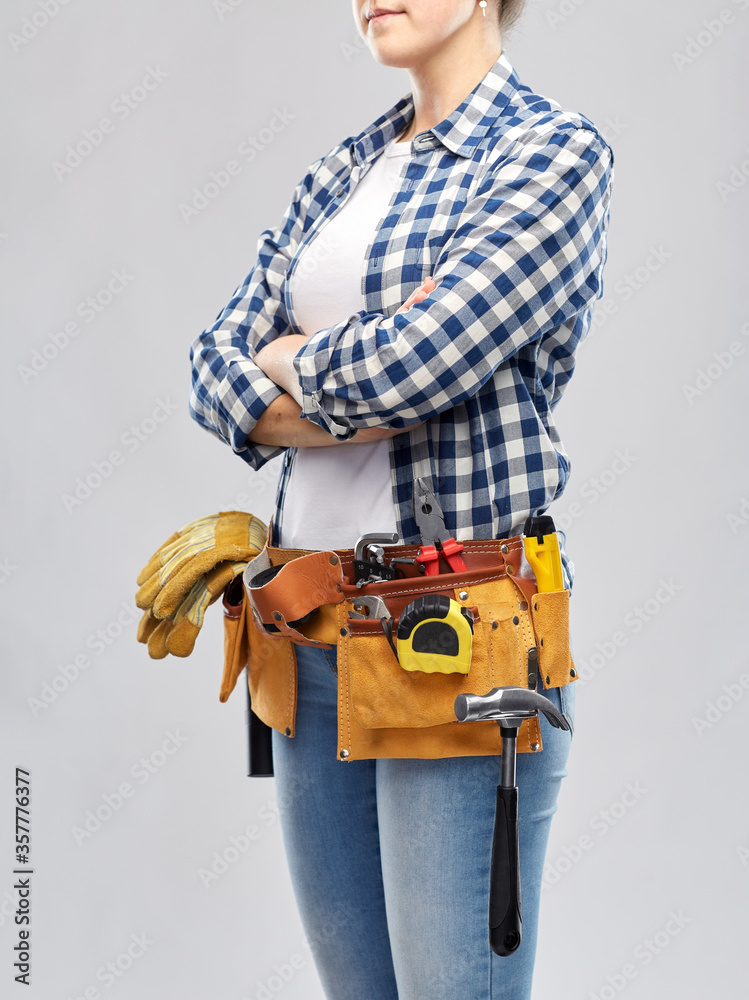 repair, construction and building concept - woman or builder with working tools on belt over grey background repair, construction and building concept - woman or builder with working tools on belt over grey background