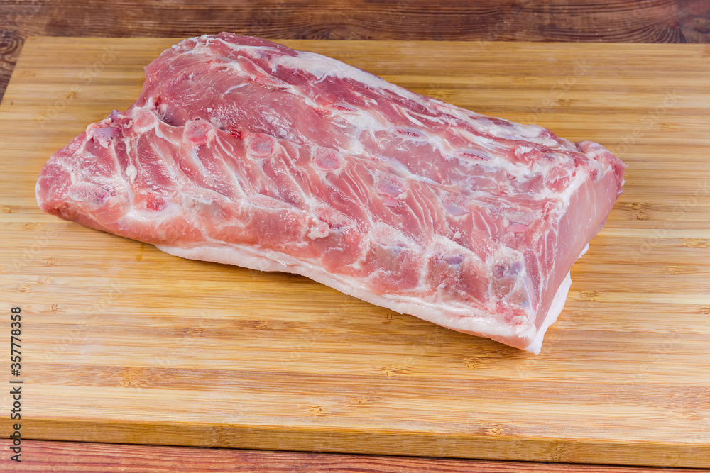 Piece of the uncooked pork loin on the cutting board