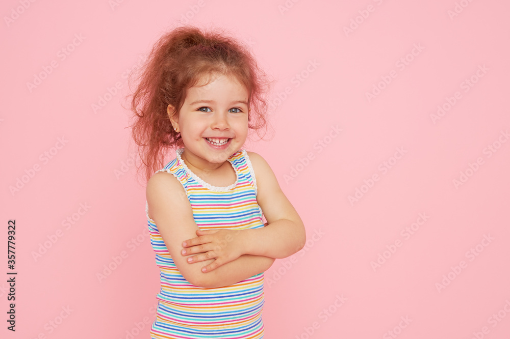 Portrait of cute little child girl with a snow-white smile and healthy teeth over pink background. looking at the camera and laughing. Dentistry for children Portrait of cute little child girl with a snow-white smile and healthy teeth over pink background. looking at the camera and laughing. Dentistry for children