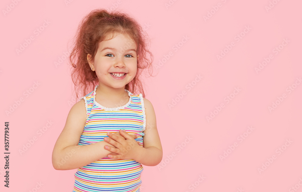Portrait of cute little child girl with a snow-white smile and healthy teeth over pink background. looking at the camera and laughing. Dentistry for children