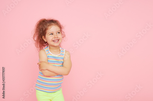 Portrait of cute little child girl with a snow-white smile and healthy teeth over pink background. looking at the camera and laughing. Dentistry for children