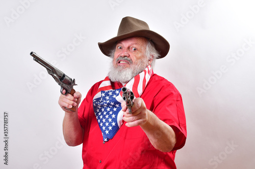 A Western rancher wearing a patriotic bandana has two pistols with one pointing at the camera..A mean looking old man with a viscous snarl point one pistol at the camera and the other to his right.