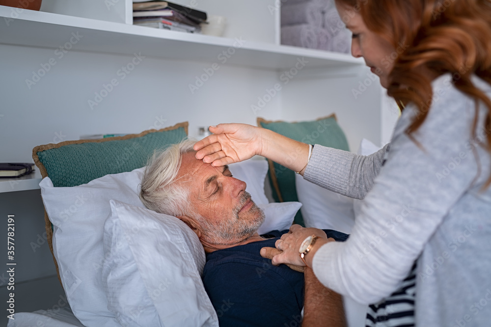 Woman checking man temperature at home Woman checking man temperature at home