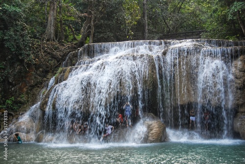 Children play happily behind the waterfall.