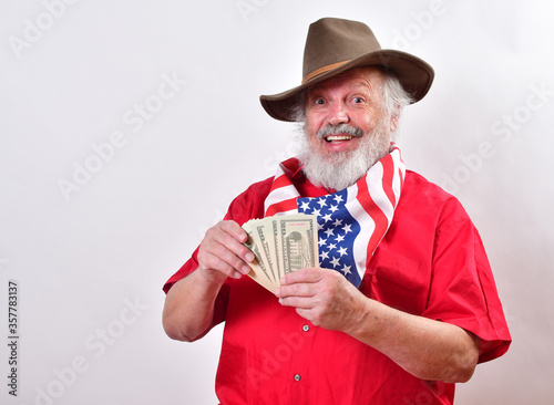 Texas cowboy with patriotic bandana and floppy hat showing off the money he earned..