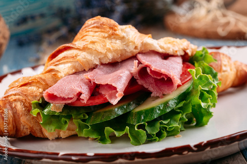 Croissant sandwich with ham and vegetables