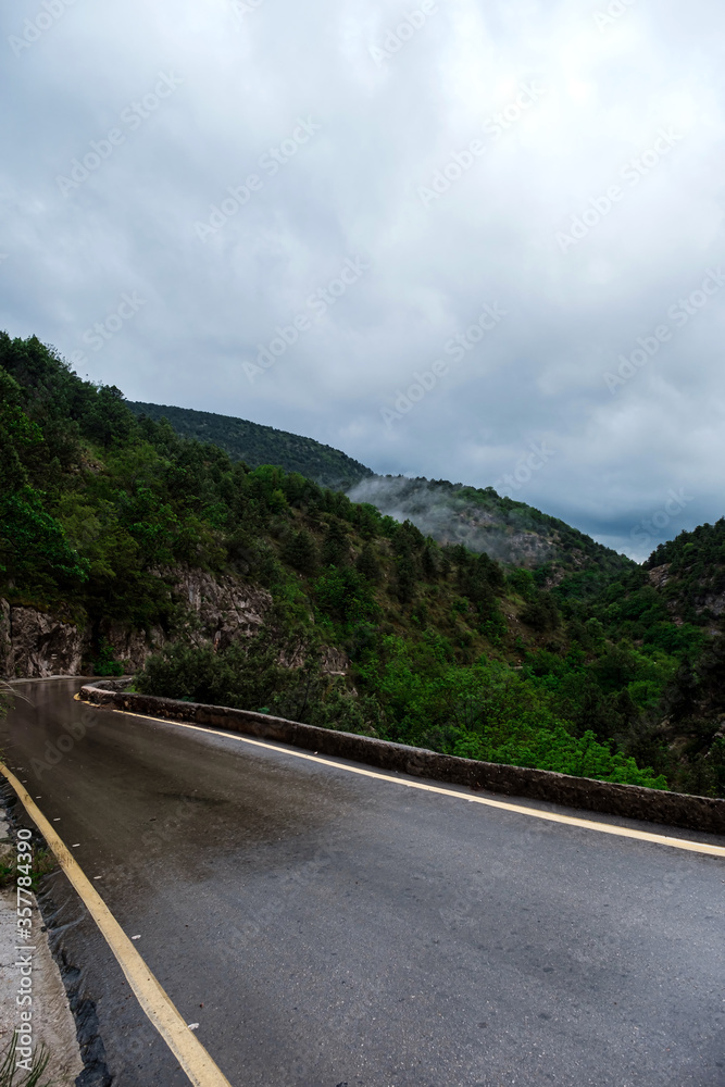 Asphalt road through the mountains forest in rainy season
