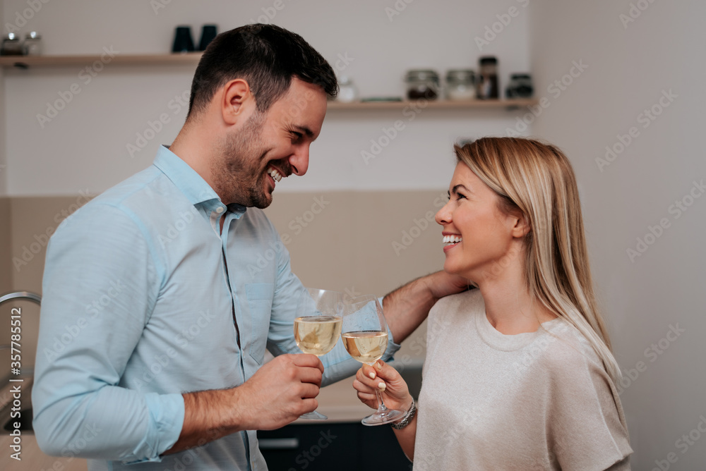 Cheerful couple drinking white wine and toasting. Cheerful couple drinking white wine and toasting.