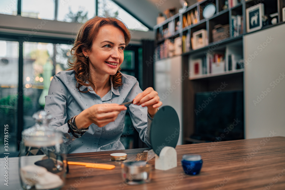 Portrait of a charming woman polishing nails with nail file at home, copy space. Portrait of a charming woman polishing nails with nail file at home, copy space.