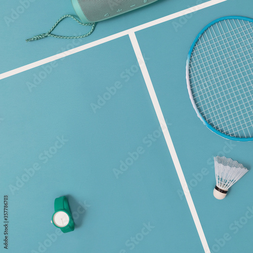 Background layout in turquoise color, a wireless speaker, a watch, a tennis racket and a roll, for design, mock-up