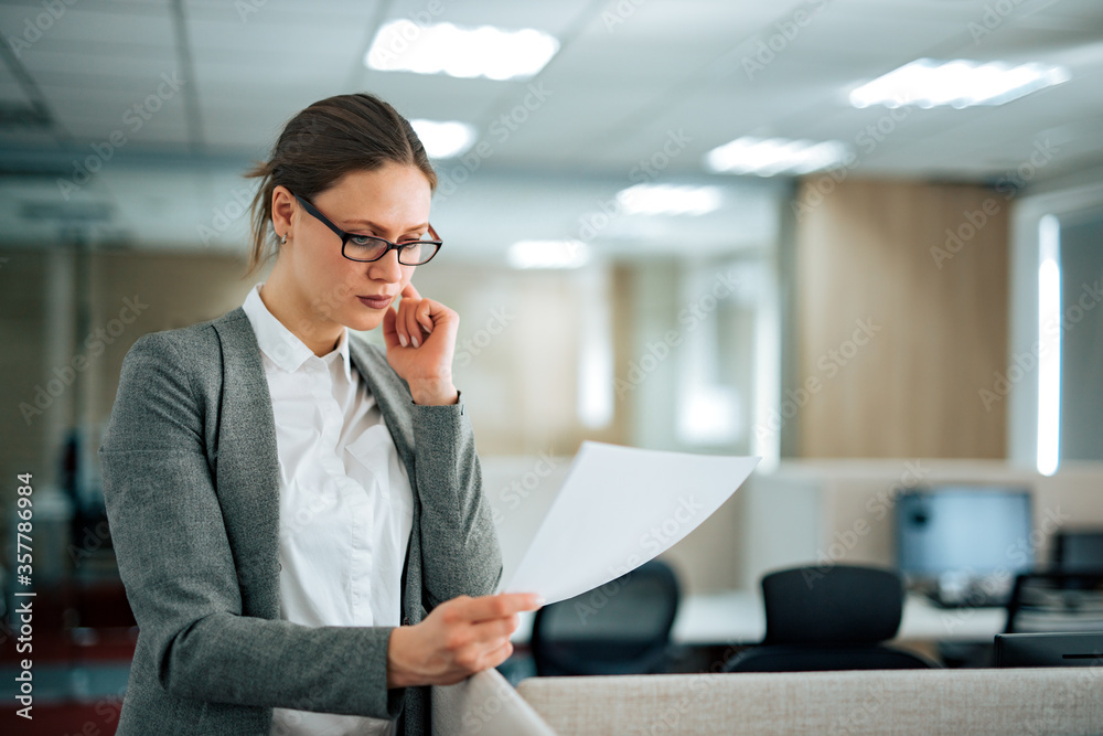 Portrait of a businesswoman reading a report, copy space. Portrait of a businesswoman reading a report, copy space.