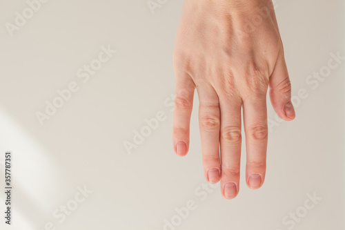  Female hand with natural manicure without gel polish on a white background with space for text. Hand energy