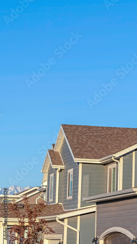 Vertical crop Row of houses in a suburb neighborhood with mountain and blue sky background
