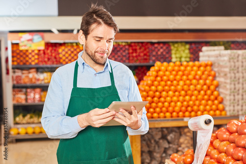 Supermarkt Verkäufer mit Tablet Computer photo