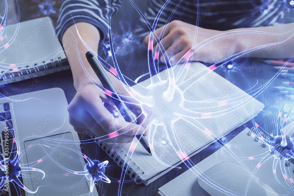 Neuron hologram over hands taking notes background. Concept of research and study. Double exposure Neuron hologram over hands taking notes background. Concept of research and study. Double exposure