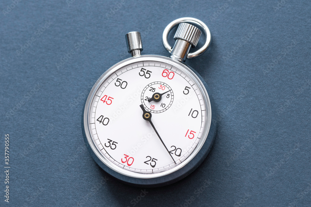 Analogue metal stopwatch on the blue background.