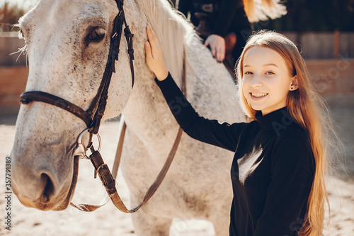 Girls with a horse. Women in a ranch. Blonde in a black sweater © prostooleh