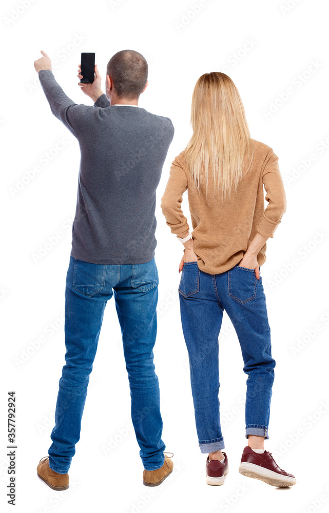 Back view of couple in sweater with mobile phone. Back view of couple in sweater with mobile phone.