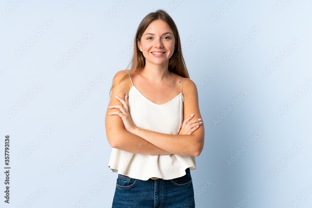 Young Lithuanian woman isolated on blue background keeping the arms crossed in frontal position