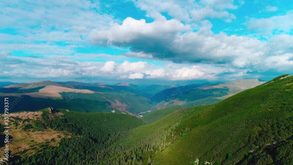 Aerial: Flying sideways on a sunny day over valleys with vast expense of pine forest in the carpathian mountains of Romania. Aerial: Flying sideways on a sunny day over valleys with vast expense of pine forest in the carpathian mountains of Romania.