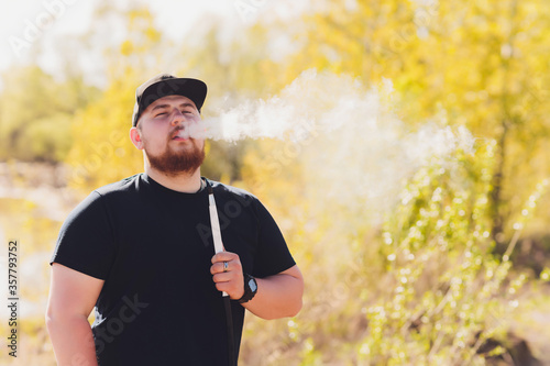 Man smoking shesha, hookah near the lake alone. photo