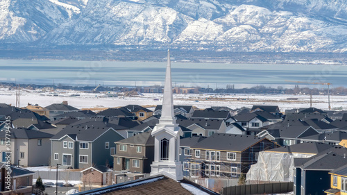 фотографія Panorama Church spire against neighborhood homes with snowy mountain and scenic
