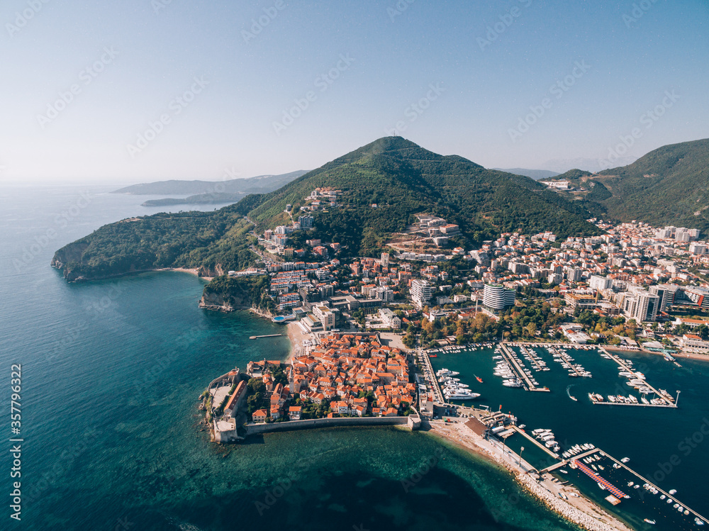 Aerial photo from the drone - the old town of Budva and boat dock and port for yachts, near the walls of the city.