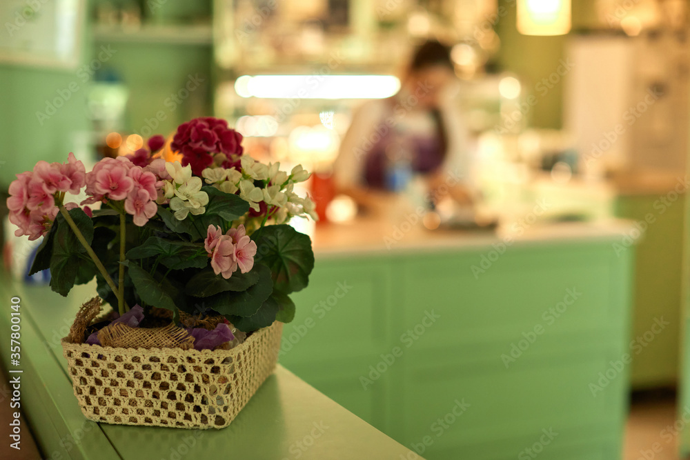 basket with flowers and blur woman working in confectionery shop. sweet store basket with flowers and blur woman working in confectionery shop. sweet store