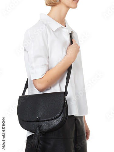 Beautiful blonde girl wearing a white shirt and dark pencil, with a black leather bag on her shoulder, on a white background, shooting in the studio