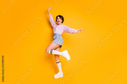 Full length body size view of her she nice attractive lovely pretty glad positive slender cheerful cheery girl dancing having fun time isolated on bright vivid shine vibrant yellow color background