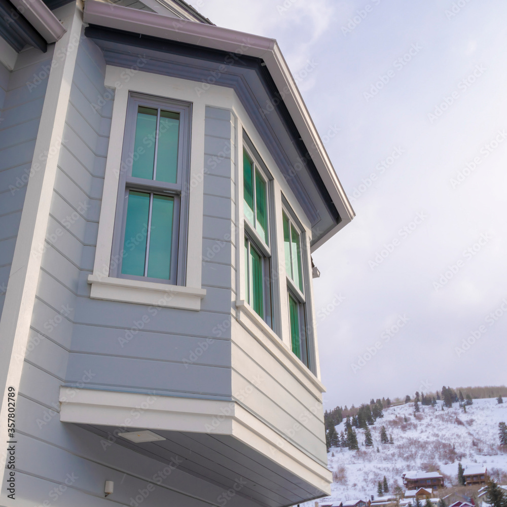 Square frame Home exterior in Park City Utah with bay window and gray horizontal wall siding