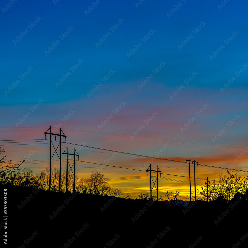 Square Electricity posts silhouetted against blue sky in Provo Canyon Utah at sunset