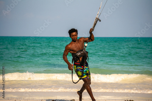 Young Attractive Muscular and Strong Athletic Black African Man Kite Surfing Instructor Teacher at the White Sand Beach