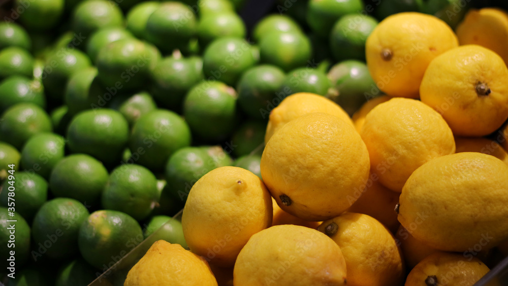 Lots of Fresh lime and lemon selling on stall or shelf at store,supermarket