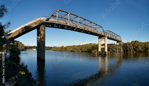 Panoramic view of pedestrian and water pipe bridge across a calm Parramatta river near Rydalmere, New South Wales, Australia © Ivan